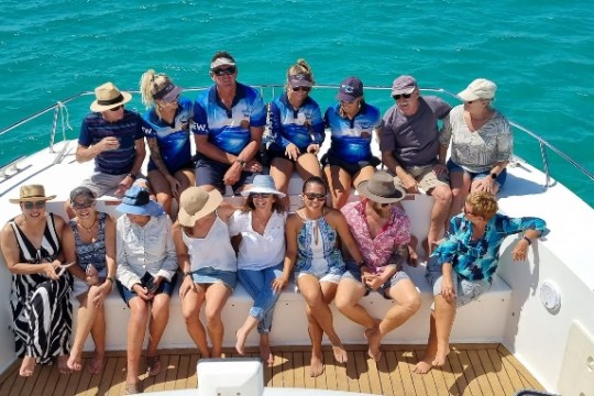 a group of people standing next to a body of water
